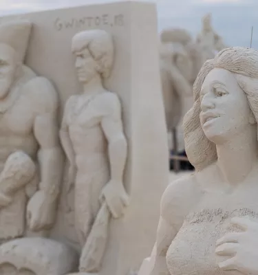 An intricate sand sculpture showing a primitive family as part of Sanding Ovations, a yearly sand-sculpting festival on Treasure Island.