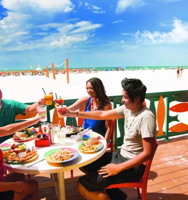 Family toasting at open-air table overlooking the beach