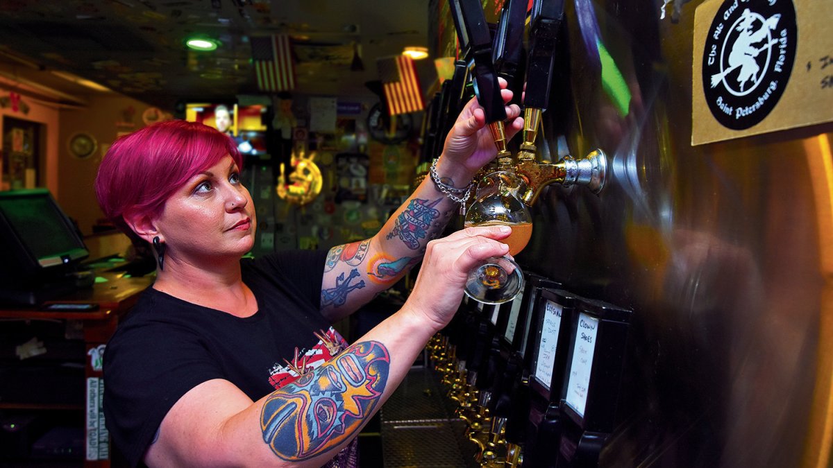 A bartender pours beer at the Ale & The Witch