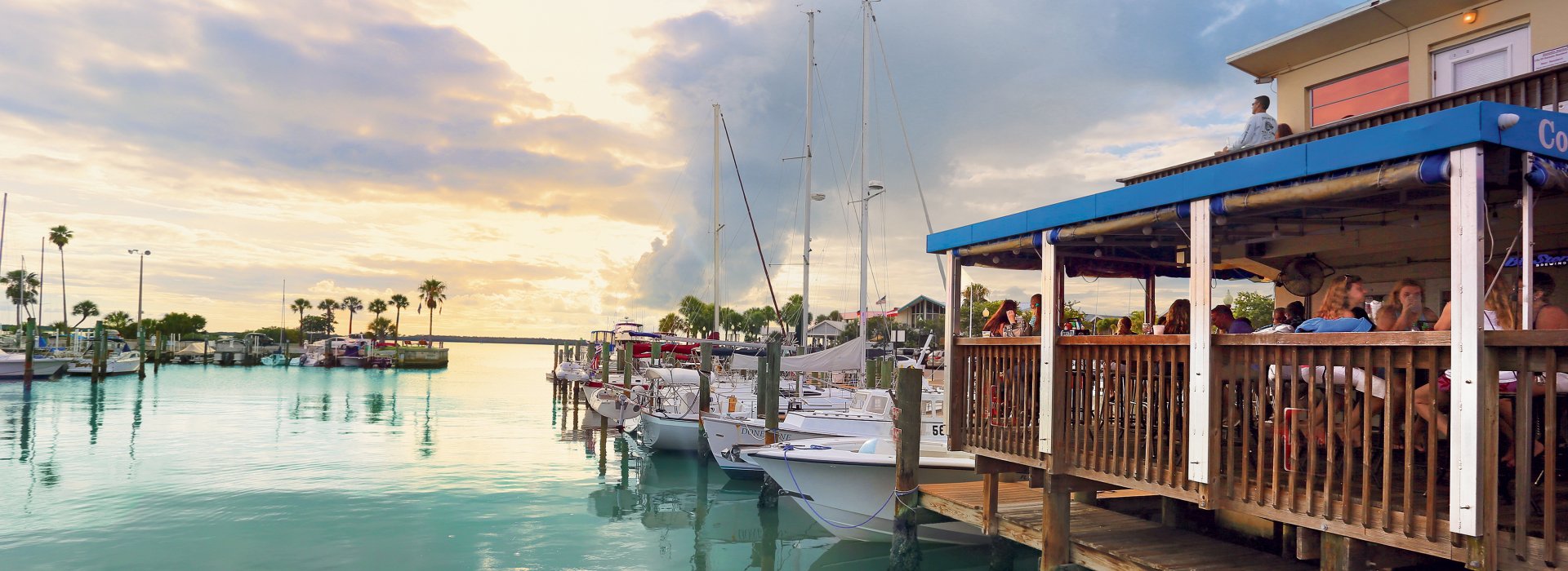 The soft light of sunset is seen over the water and dock at the Dunedin Marina