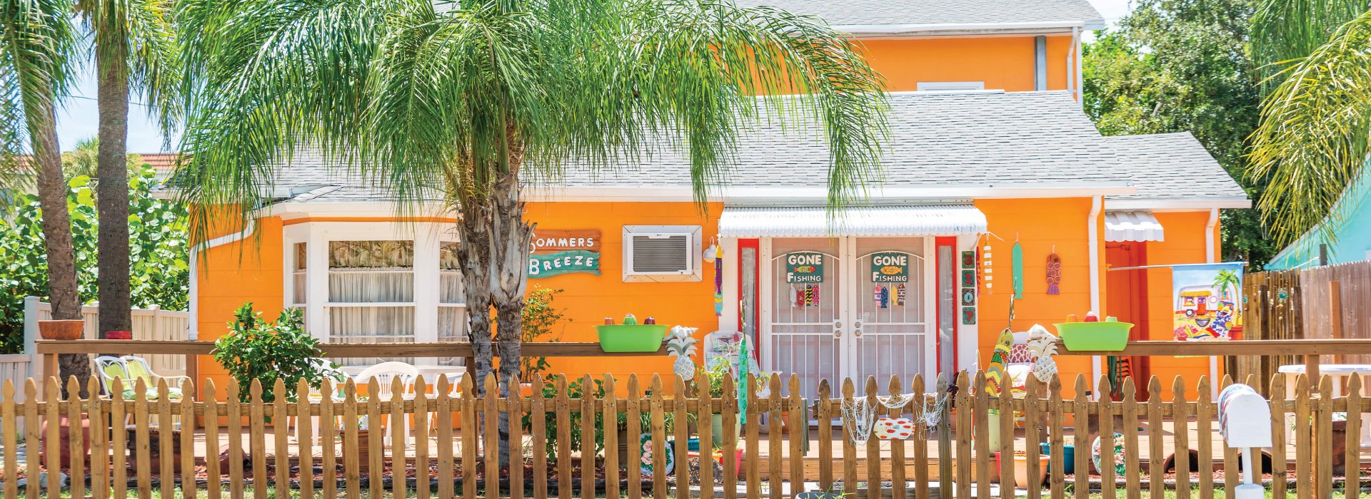 An incredibly orange house in Gulfport with a picket fence and gone fishing signs on the door