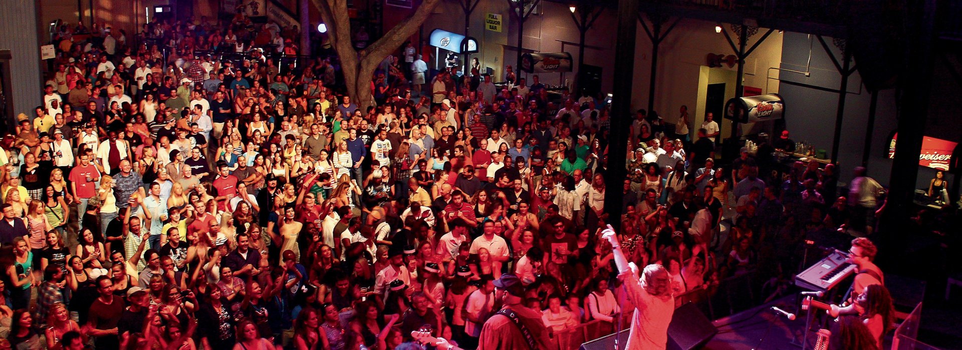 A band plays in front of a tightly packed crowd of people at Jannus Live