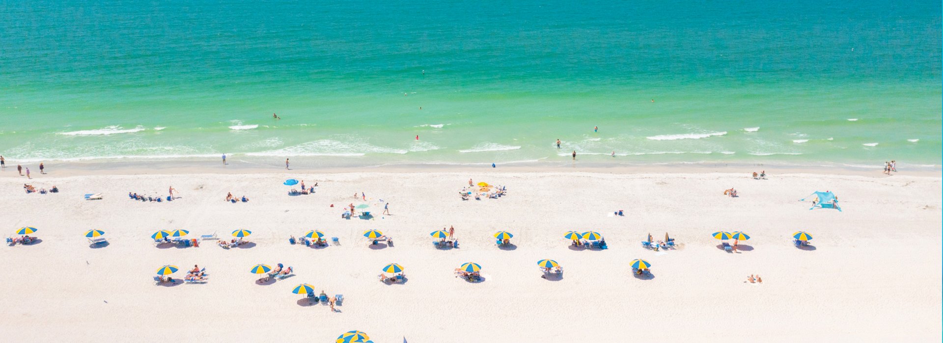 Treasure Island Beach aerial view of green waters and yellow cabanas