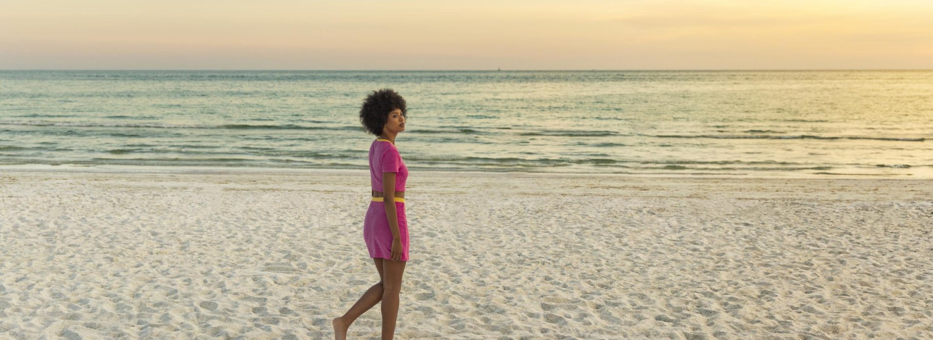 A woman walks by herself on the beach