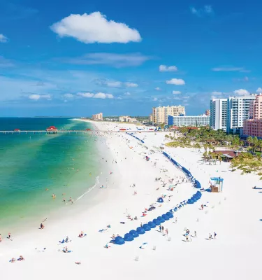 Aerial view of lively Clearwater Beach with white sands and emerald-green waters