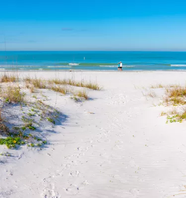 A couple walking in the white sands of Redington Shores