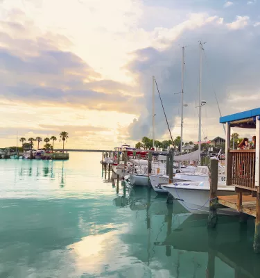 The soft light of sunset is seen over the water and dock at the Dunedin Marina