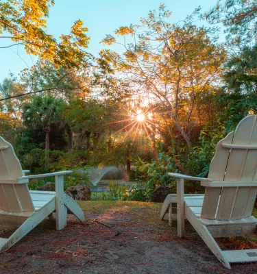 Lounge chairs over look trees, a pond and a fountain at Florida Botanical Gardens in Largo.