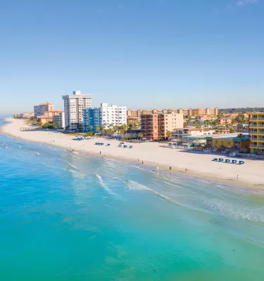 Aerial view of North Redington Beach with calm, blue-green Gulf waters to the west and condos to the east