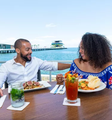 A couple dines and enjoys cocktails at Doc Ford's Rum Bar & Grille with the St. Pete Pier in the background