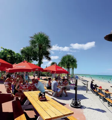 People outside dining at Paradise Grille, which overlooks Pass-A-Grille beach
