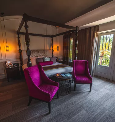 Magentafarbene Stühle und antik aussehendes Schlafzimmer mit französischen Türen im Boutique-Hotel The Birchwood