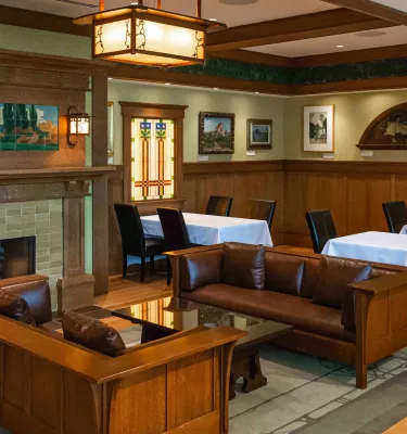 A restaurant dining room featuring wooden furniture, stained glass and hand-painted tiles.