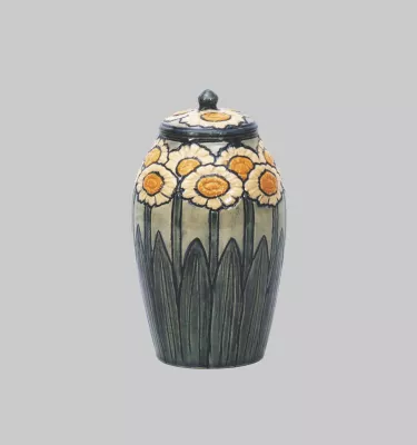 A lidded ceramic jar with hand-painted daisies.