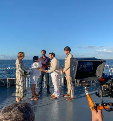 A man and a woman get married on a boat with a view of the water.