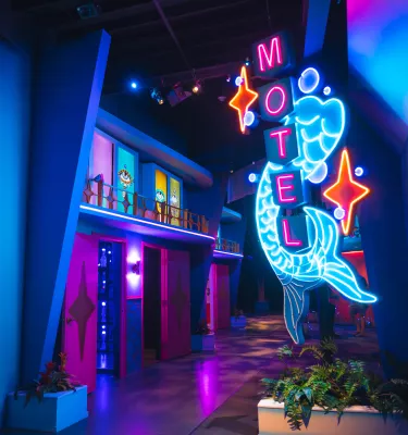A neon sign outside an artistic replica of a vintage Florida hotel