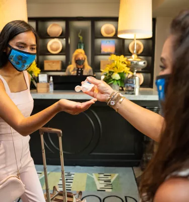 A visitor puts hand sanitizer on as she enters the lobby