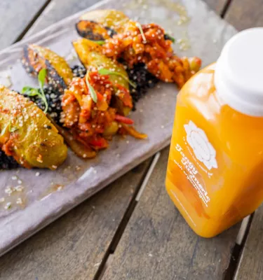 A fresh orange juice and a colorful plate of plant-based foods at Karma Juice Bar