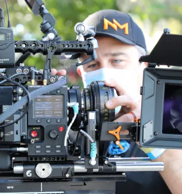 Person behind the scenes working a camera