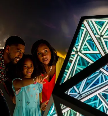 A family looks at glass art at the Imagine Museum