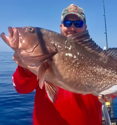 A fisherman holds up a recently caught fish