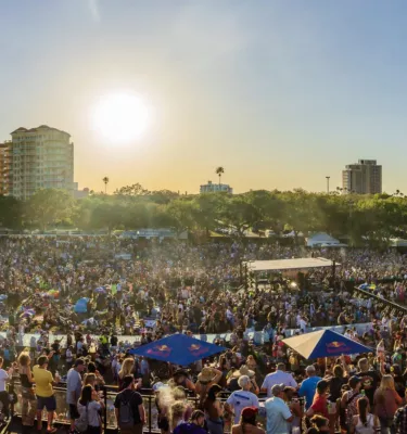 Skyline image of downtown St. Pete with a crowd of people attending the Reggae Rise Up Festival at Vinoy Park.