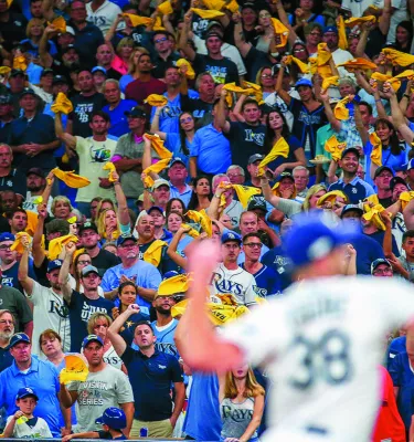 A lively crowd in Tropicana Field cheers as a fielder throws the ball.