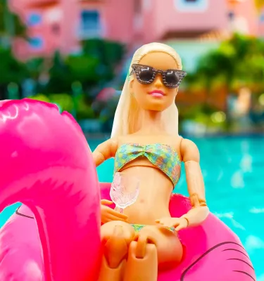 barbie in a bikini and sunglasses riding a flamingo float in the pool at the Don CeSar