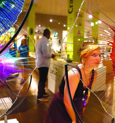 Woman shopping surrounded by colorful glass sculptures.