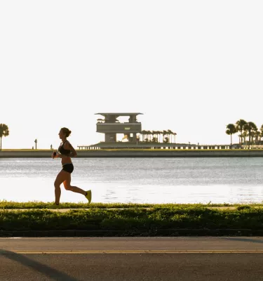 a runner near Tampa Bay with the St. Pete Pier in the background