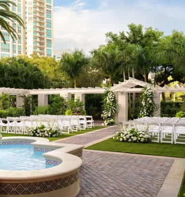 outdoor wedding setup with white chairs on lawn with white flowers at the Vinoy Resort