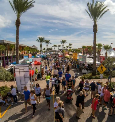 many people walking near food trucks and vendors at the John's Pass Seafood Festival in Madeira Beach