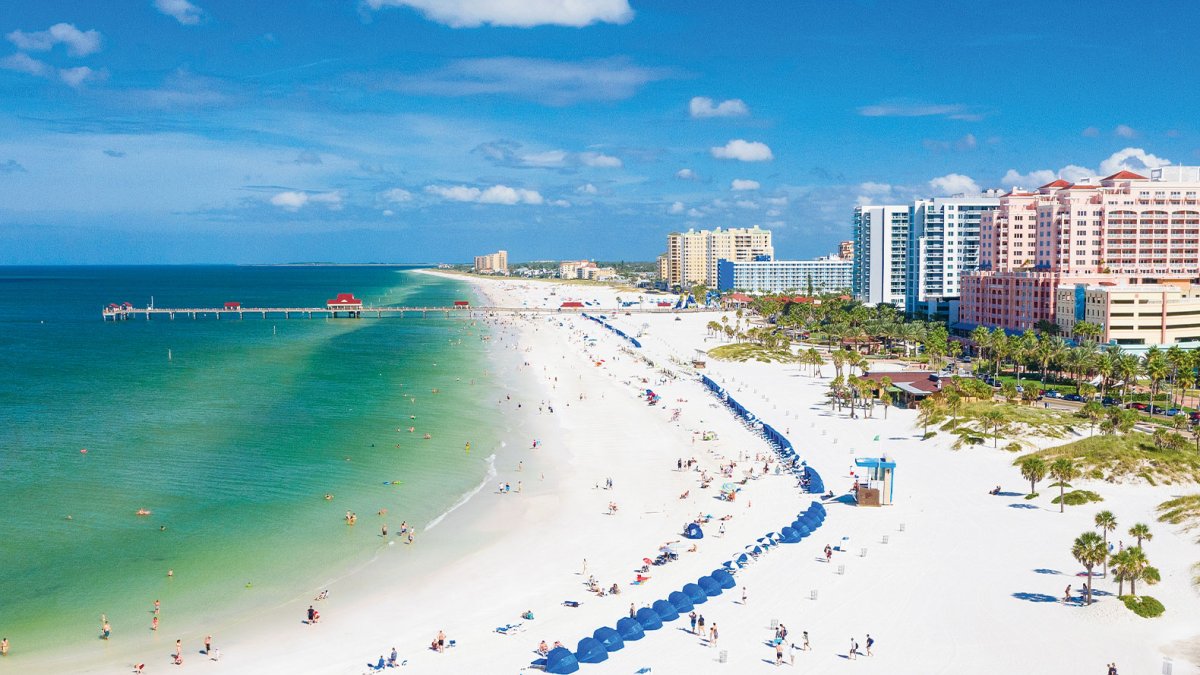 Aerial view of lively Clearwater Beach with white sands and emerald-green waters