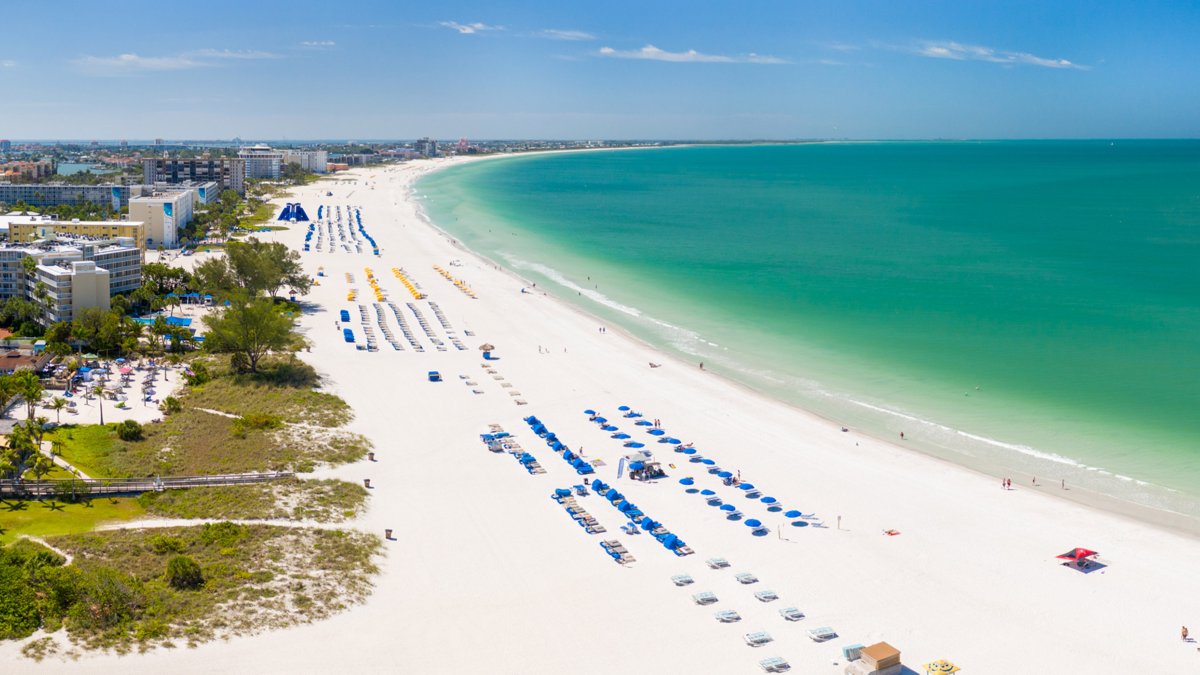 Luftaufnahme von St. Pete Beach von Norden, einschließlich weißem Sand, blauem Wasser und schattigen Cabanas.