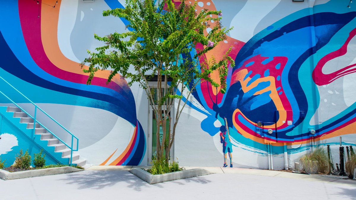 Un mural con remolinos de colores brillantes llamado "Make Believe" de Tes One en Main Street en Dunedin