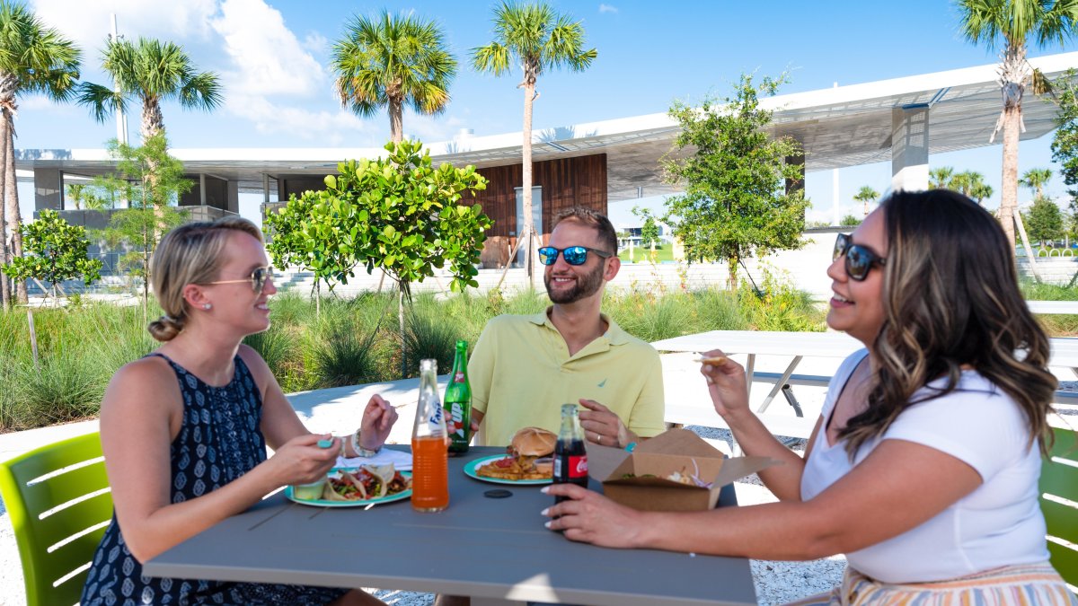 A group of friends enjoying a meal in an outdoor setting.