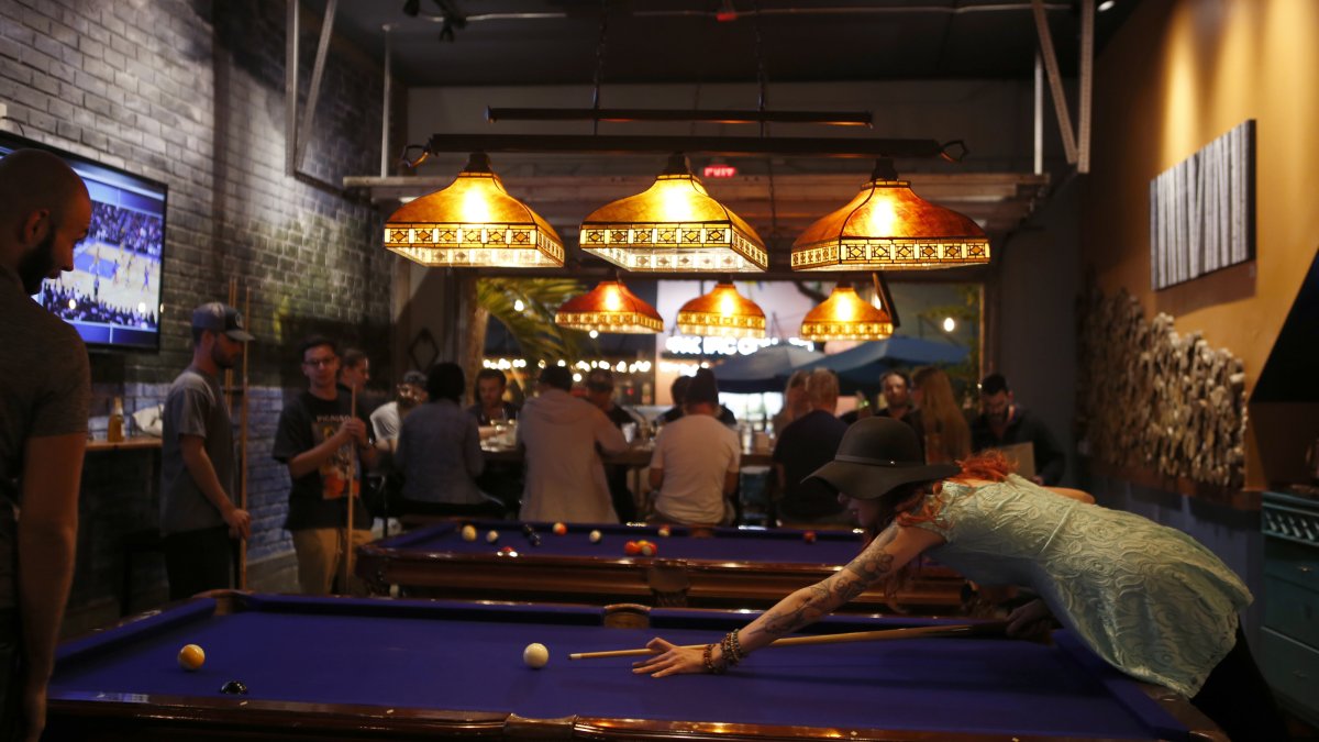 Ein Paar spielt nachts in einer Bar Billard.