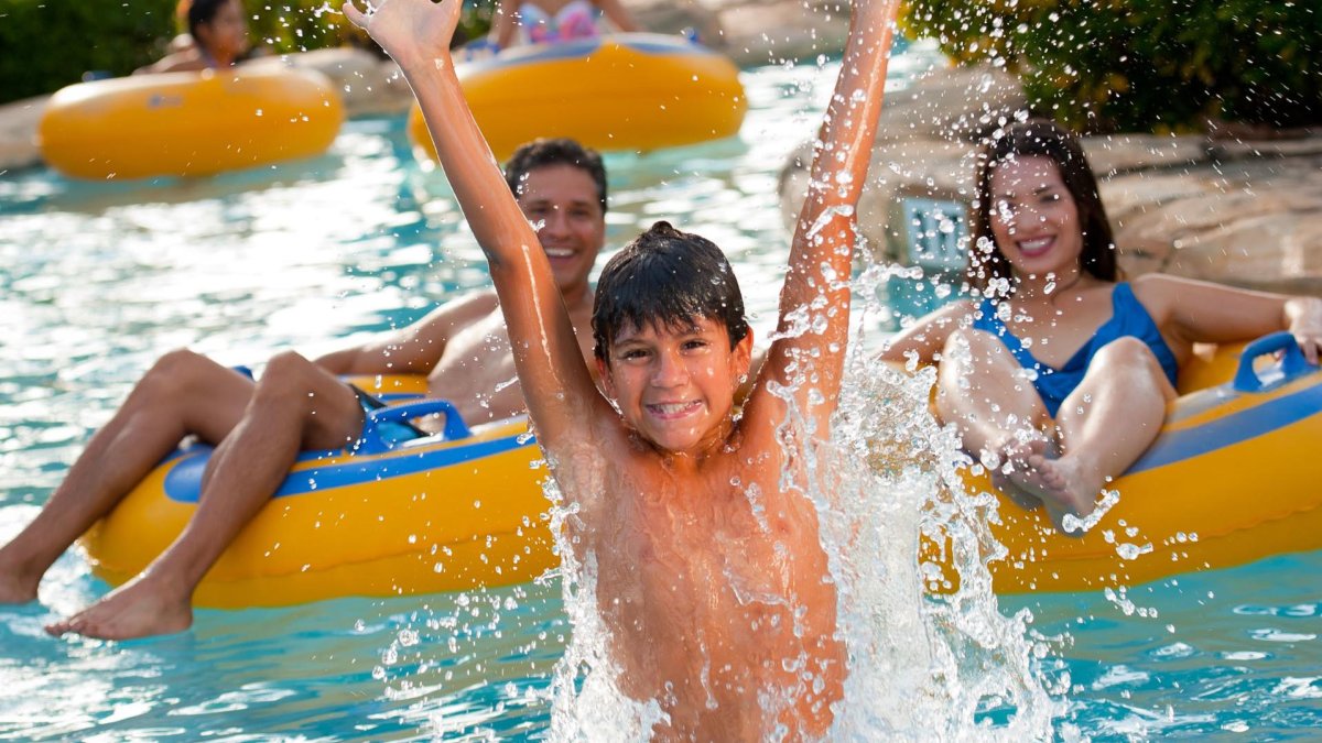 A boy jumps out of the water at a pool in Adventure Island