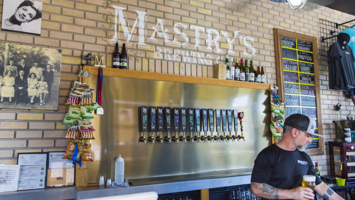 A bartender holding a beer glass at Mastry's Brewing Co. in St. Pete Beach.