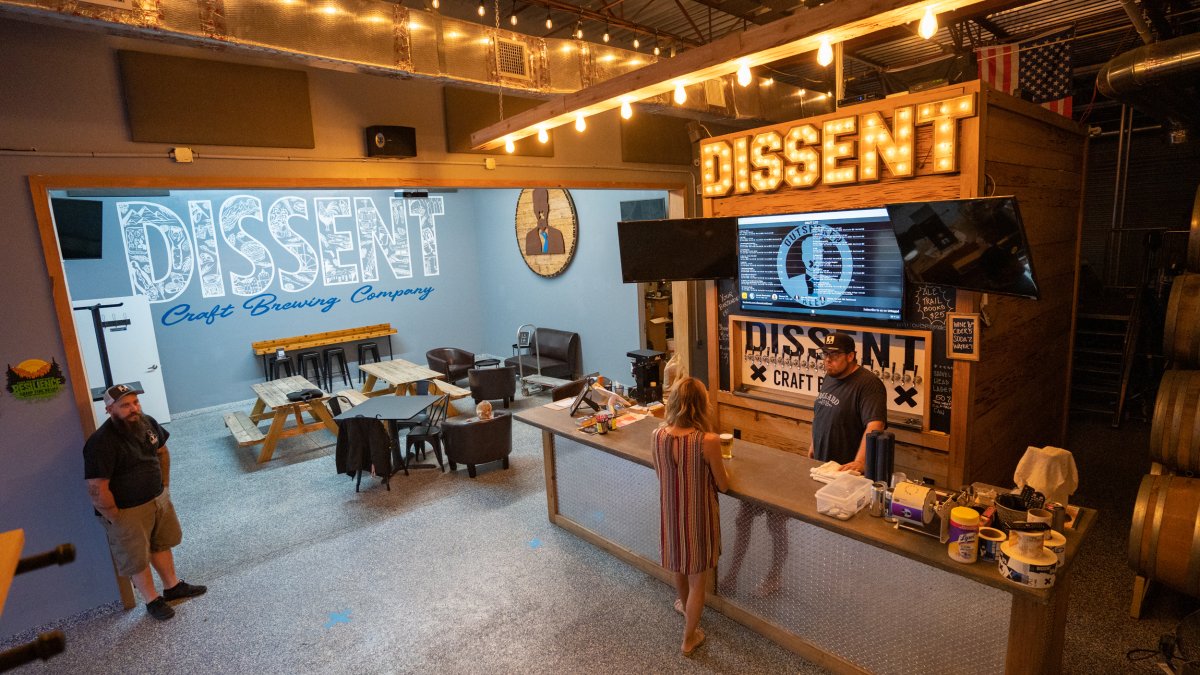 A woman shopping for beer inside Dissent Brewing.