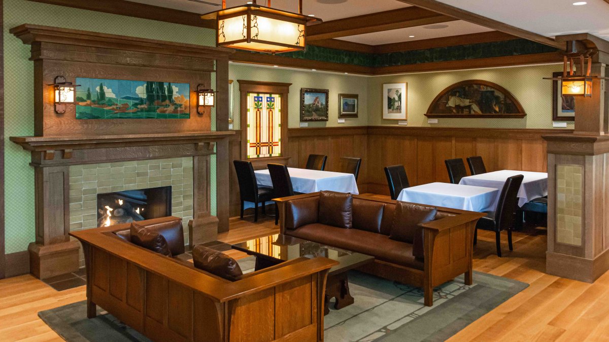 A restaurant dining room featuring wooden furniture, stained glass and hand-painted tiles.