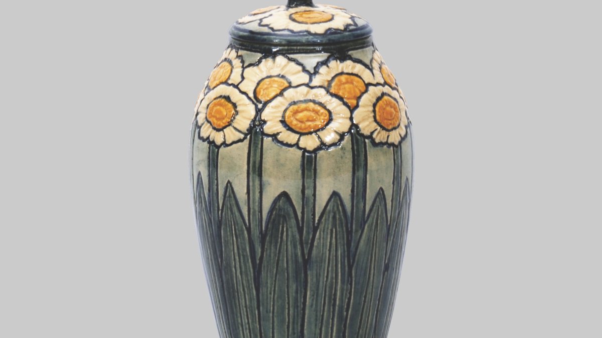 A lidded ceramic jar with hand-painted daisies.