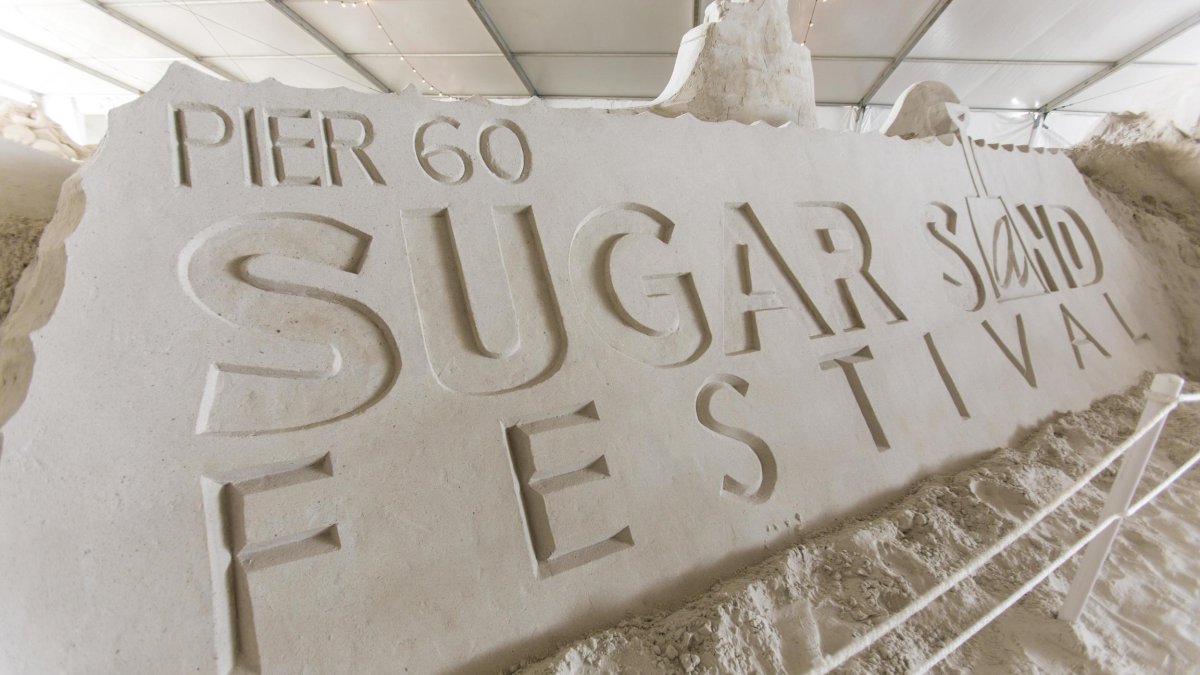 A sandsculpture reads Pier 60 Sugar Sand Festival.