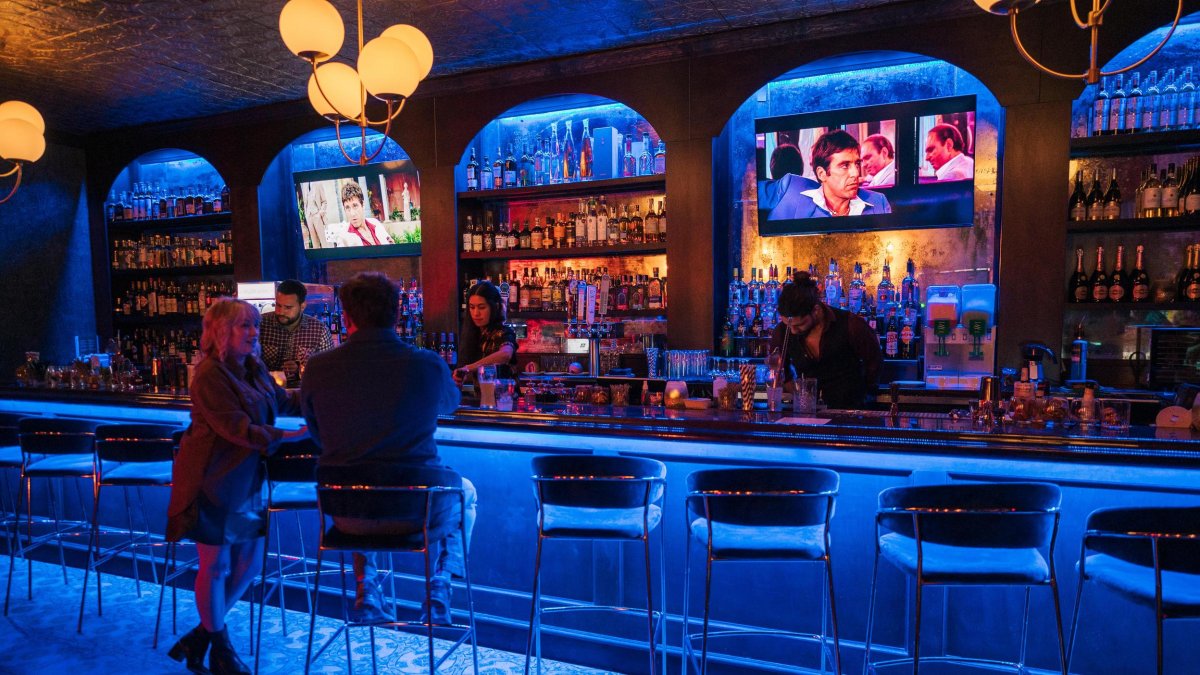 a man and a woman at the bar inside Dirty Laundry in St. Pete under blue and yellow lights