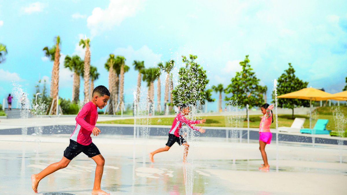 Two boys and a girl play at the splash pad at the St. Pete Pier