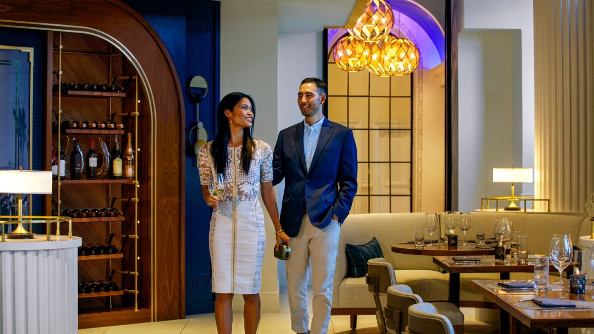 A young Asian couple in nice clothing walks into the elegant Maritana restaurant at the Don CeSar resort