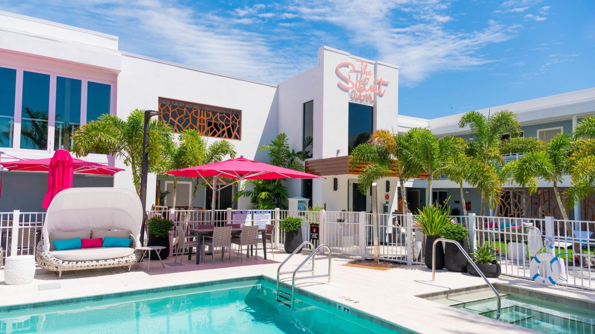 Outside photo of The Saint Hotel in St. Pete Beach. Featuring an outdoor pool with pink and teal colors.