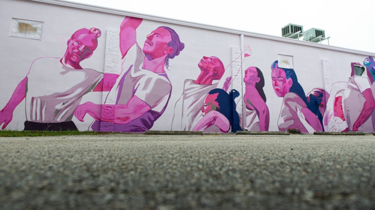 a mural of dancers in white shirts with shades of pink and purple