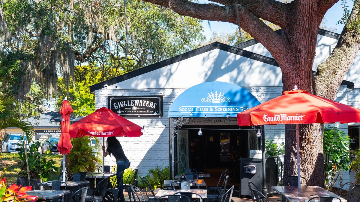 Exterior of Gigglewaters with outdoor dining tables by small white building