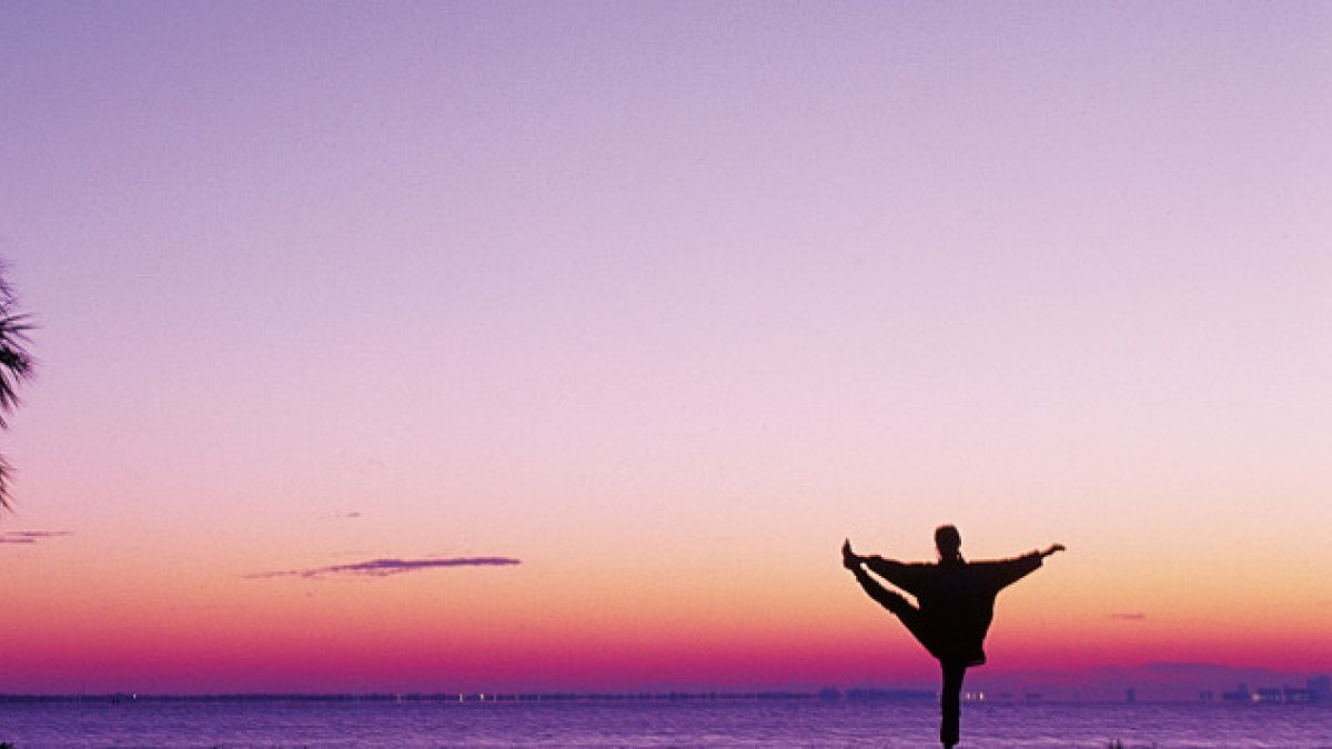 person doing yoga at sunrise